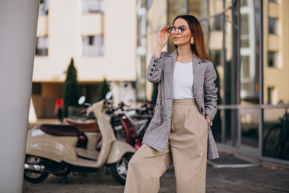 Femeie elegantă cu ochelari de soare în decor urban